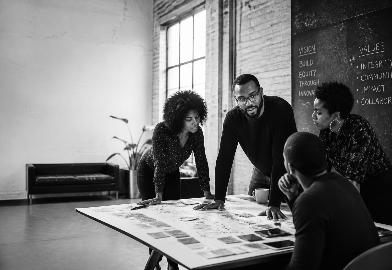 Black founders and community leaders collaborating around a table of strategy notes